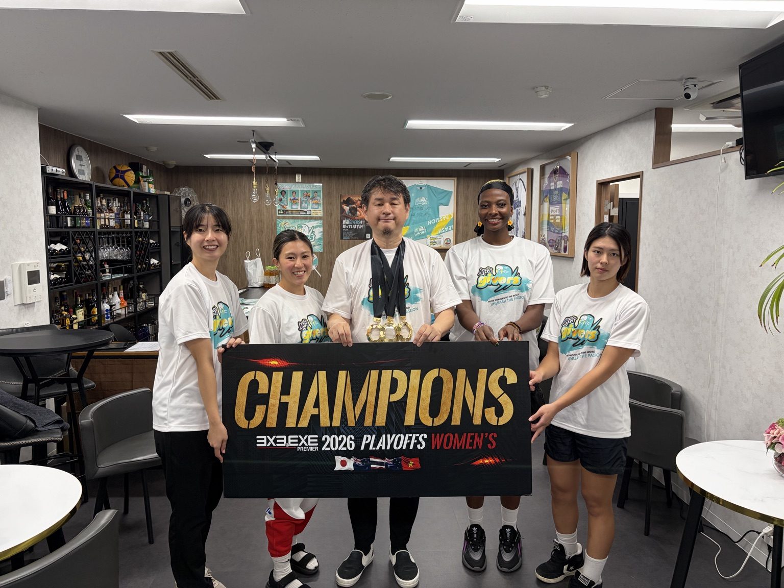 PLAYOFFS優勝ボードを持つ新宿GIVERSの選手たち
